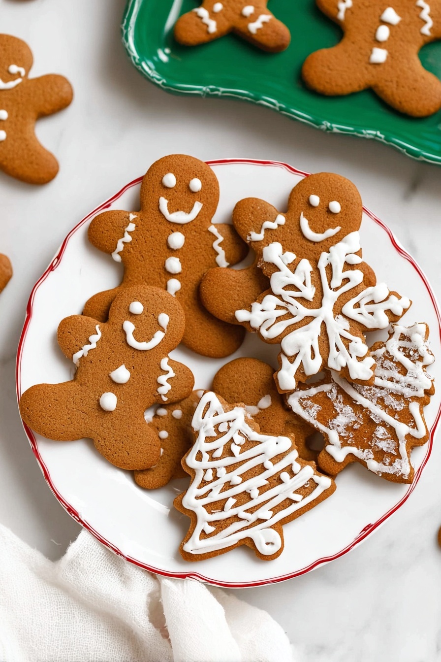 A white plate with a red rim holds several gingerbread cookies in different shapes: two gingerbread men with white icing faces, buttons, and scarves, a snowflake with detailed white icing in the form of branches, two Christmas trees decorated with white icing zigzags and sugar crystals, and two smaller shapes with white icing patterns. The cookies are a warm brown color with smooth texture, arranged close together. In the background, a white marbled surface and a green tray holding more gingerbread men are visible. A white cloth is partly shown in the lower corner. photo taken with an iphone --ar 2:3 --v 7